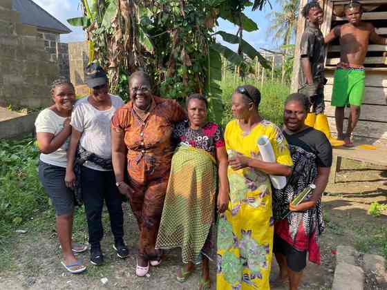Tombra Mohammed smiling with women during a community visit